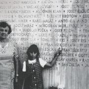 Die Enkelin von František Šiška (1893–1944) zeigt auf den Namen ihres Großvaters auf einer Gedenkwand, um 1976 (© SOkA Rokycany)