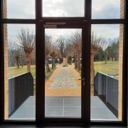 Blick aus der Gedenkstätte Großschweidnitz auf Denkmal und Namenstafeln (© GSGS / StSG)
