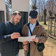 Roland Richter und Gedenkstättenmitarbeiter Christoph Hanzig vor den Namenstafeln auf dem Friedhof (StSG/GSGS)