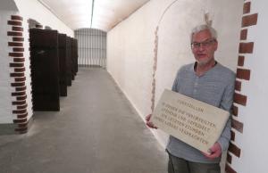 Gerald Hacke mit historischer Tafel im sanierten Zellengang der Gedenkstätte Münchner Platz Dresden