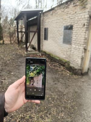 Foto des Mediaguides der Gedenkstätte Pirna-Sonnenstein vor einem alten Mauerrest