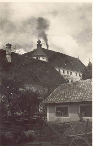 Foto der Tötungsanstalt Hartheim mit rauchendem Schornstein des Krematoriums, 1940/41 - © Wolfgang Schuhmann