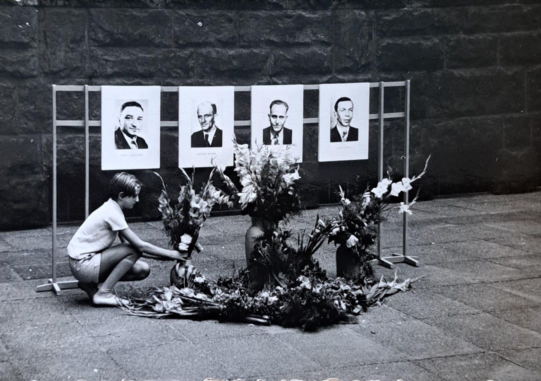 Ina Schlosser legt als Zehnjährige Blumen in der Mahn- und Gedenkstätte am Münchner Platz nieder